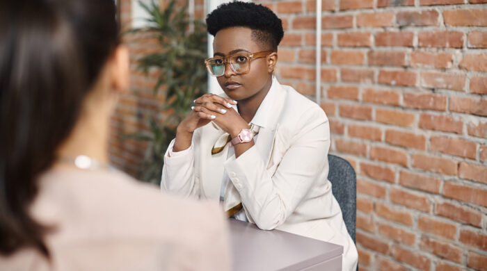 African American female executive communicating with business colleague during a meeting at corporate office.