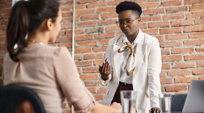 African American CEO communicating with her coworker during business meeting in the office.