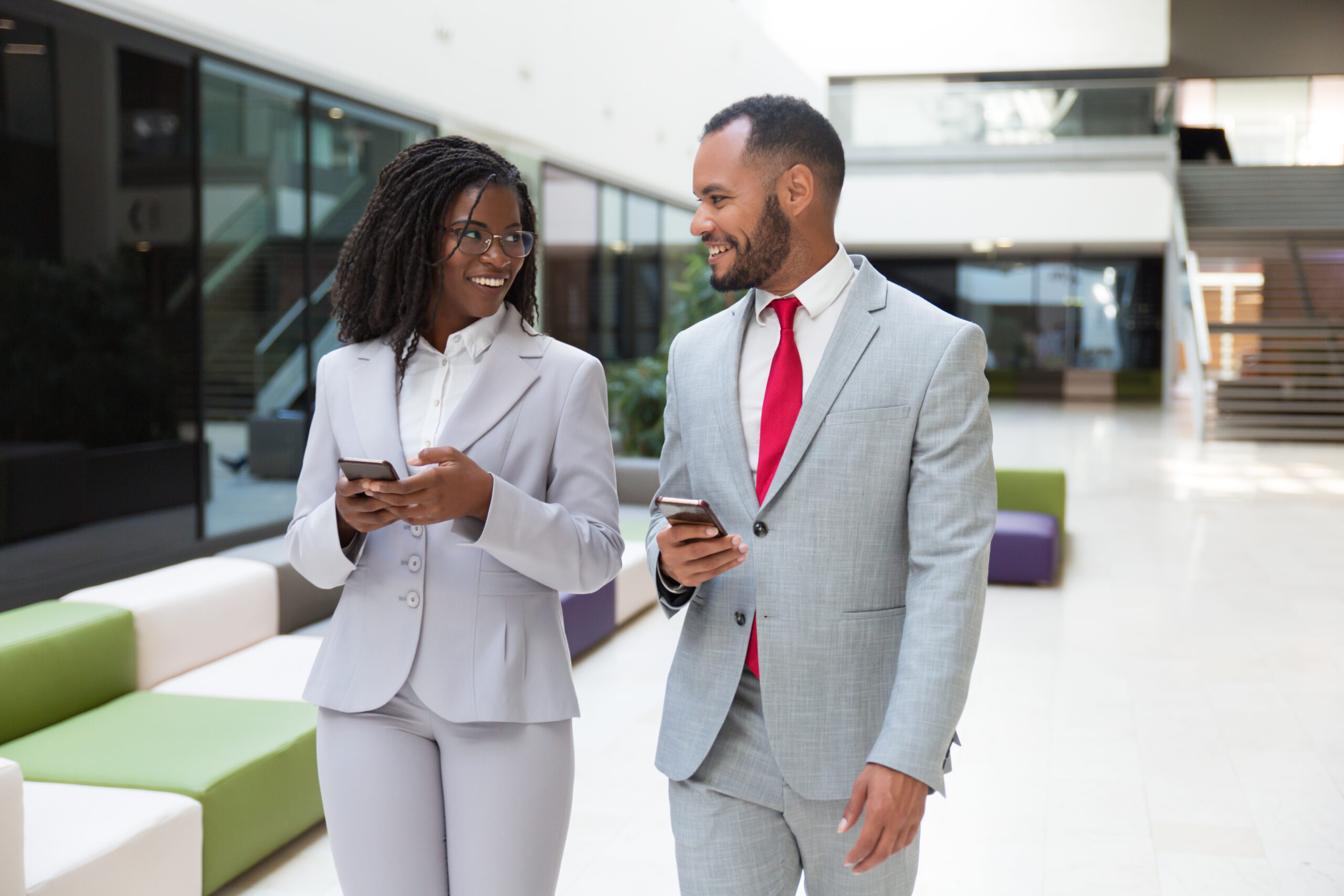 Happy Business Colleagues Using Mobile Phones And Chatting