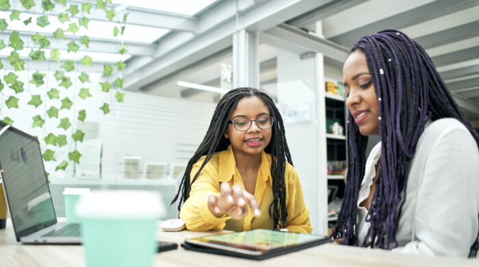 Two business girls using a tablet in the office.